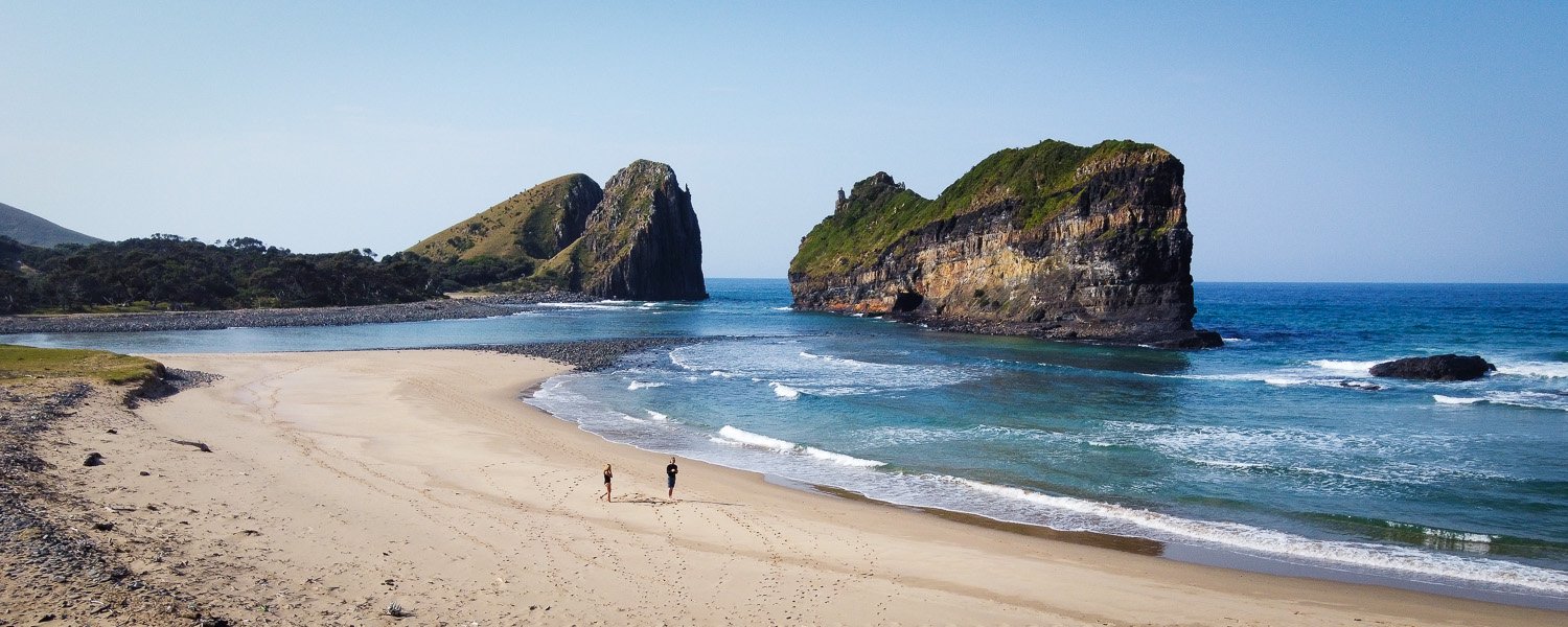 Couple walking on the beach near the Hole in the Wall