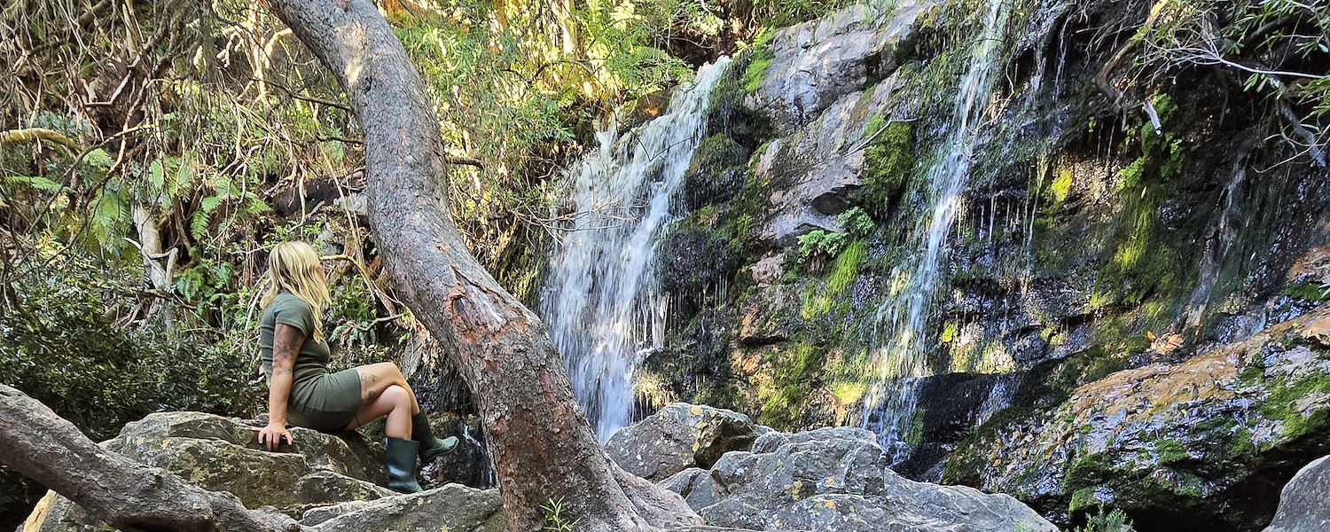 Woman sitting by the waterfall
