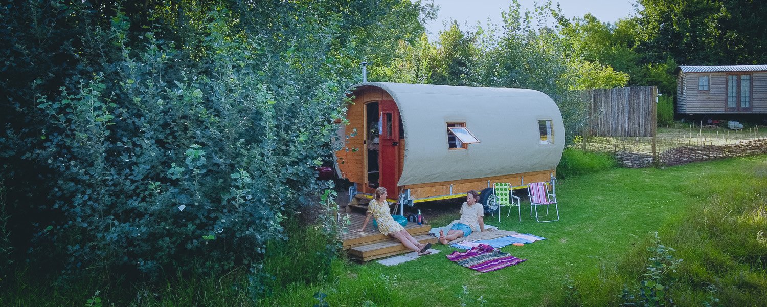 Couple relaxing and chatting outside a Gypsy Caravan