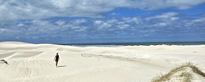 Woman walking on white sand dunes near Die Grys beach